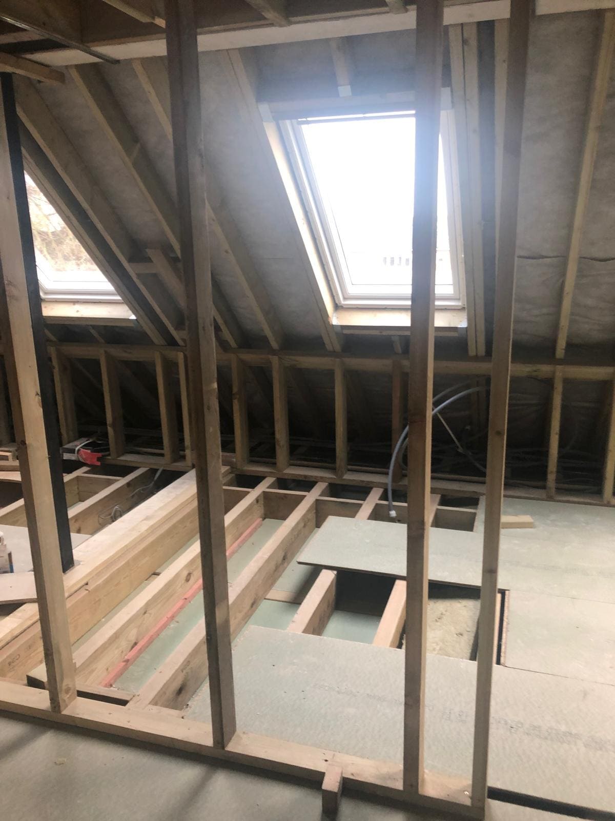 Loft conversion in progress in a London property with new stud framing, joists and Velux skylight installed