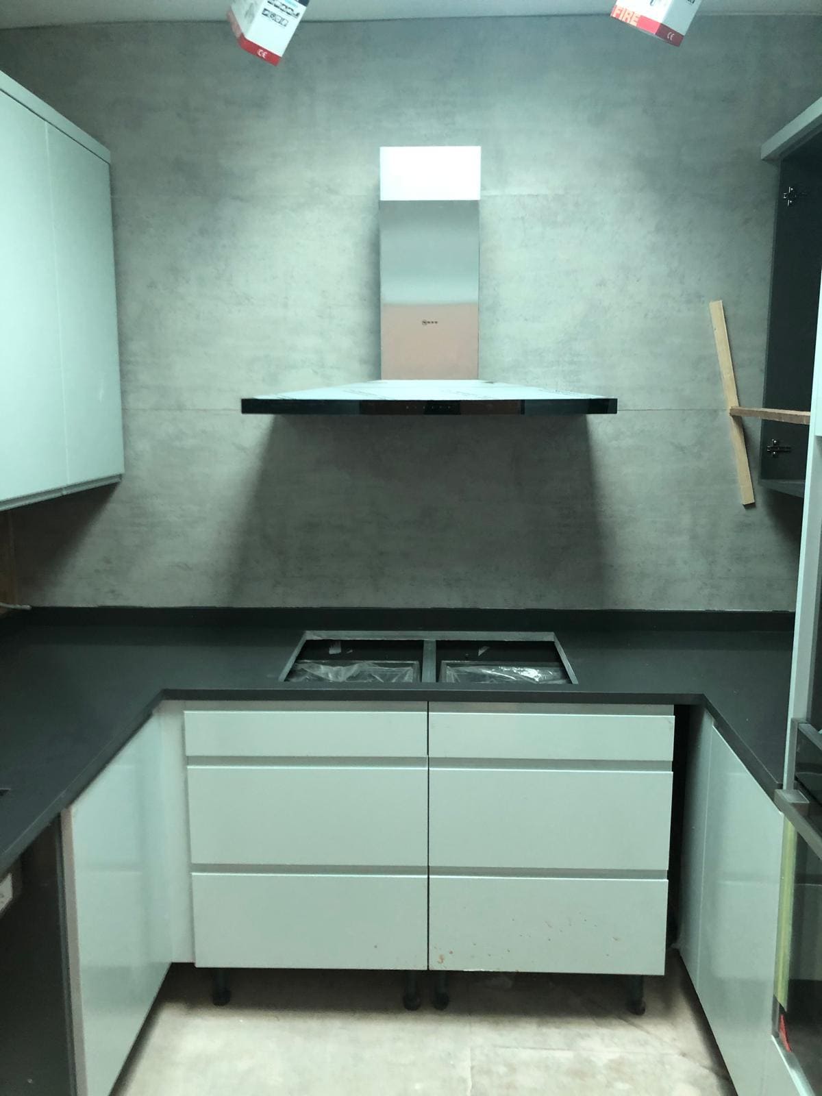 Kitchen installation in a London home with new white units, dark quartz worktop and Neff extractor hood