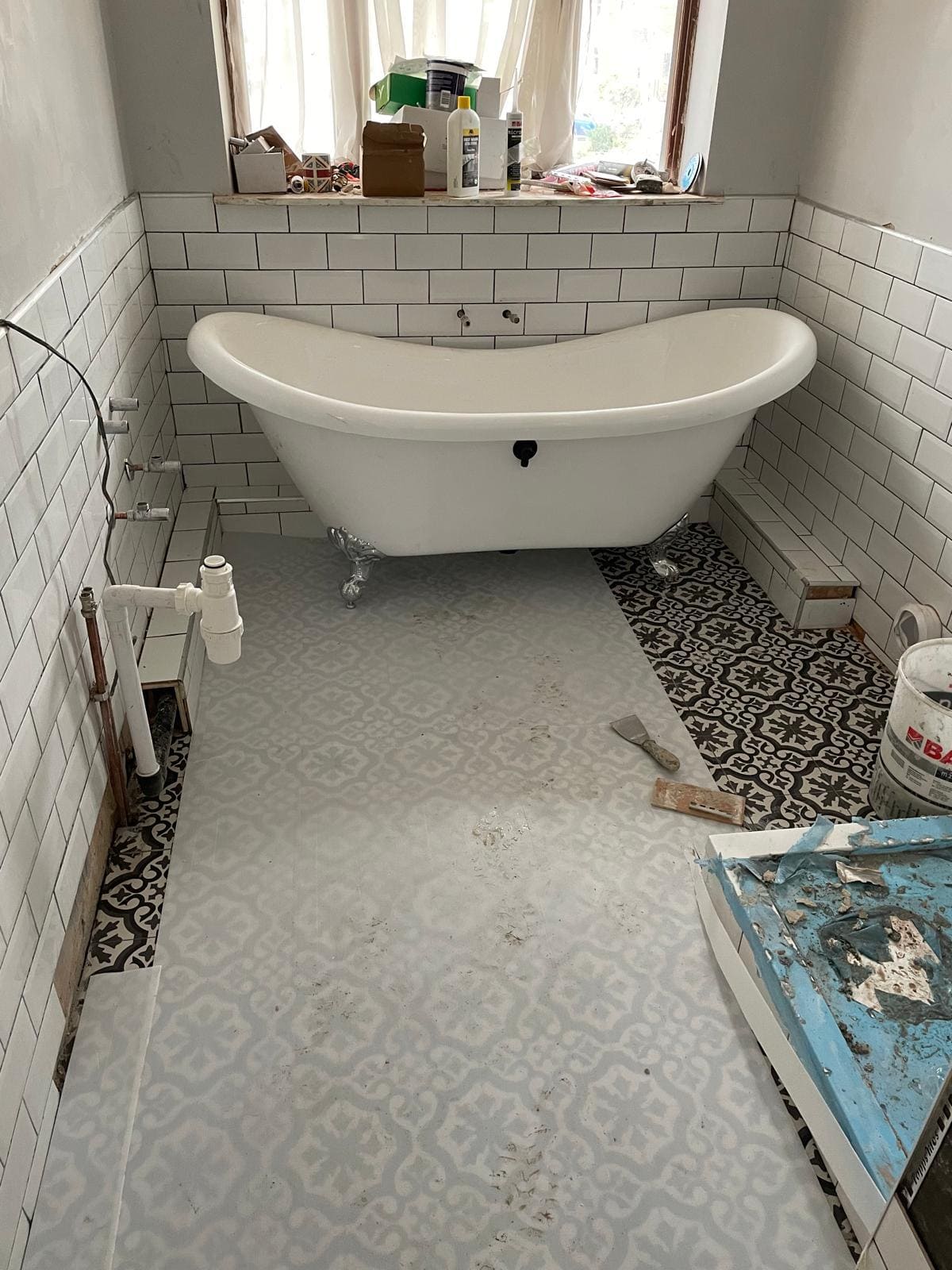 Bathroom install in London showing wall tiling and plumbing detail